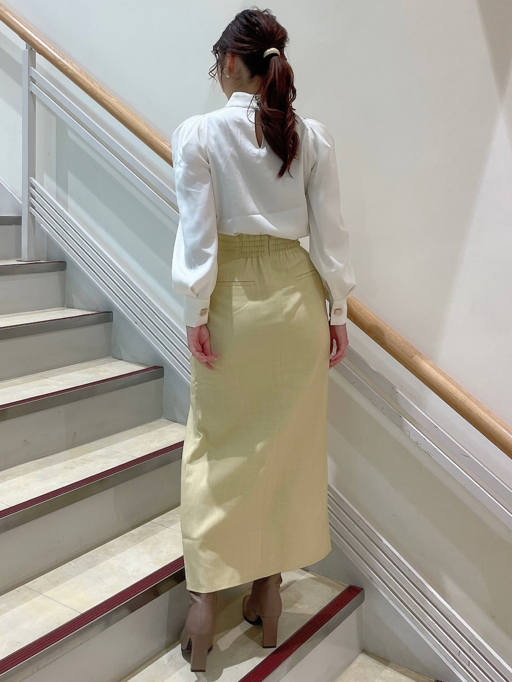 ホワイト系のシャツ/ブラウス、イエロー系のスカート、ベージュ系のブーツを着用したレディースの夏コーディネートの3枚目の写真