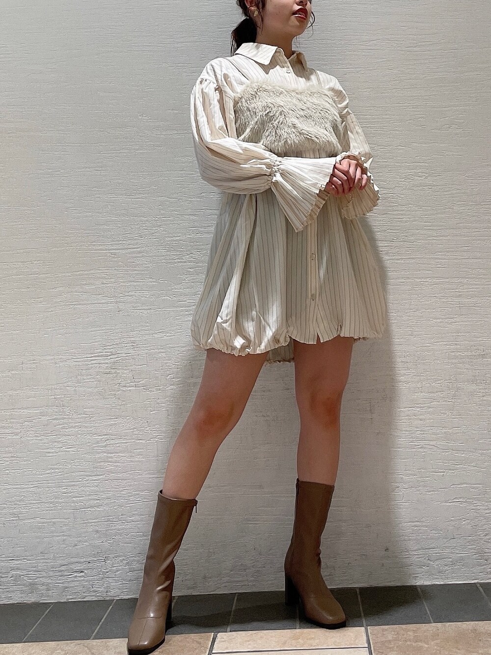 ベージュ系のベスト、ベージュ系のワンピース、ベージュ系のブーツを着用したレディースの夏コーディネートの2枚目の写真