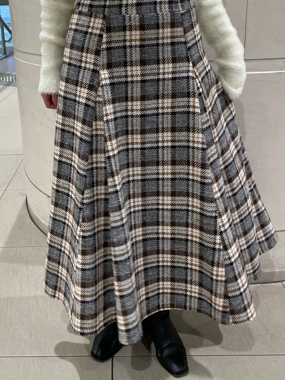 ホワイト系のニット/セーター、その他のスカート、ブラック系のブーツを着用したレディースの秋コーディネートの9枚目の写真