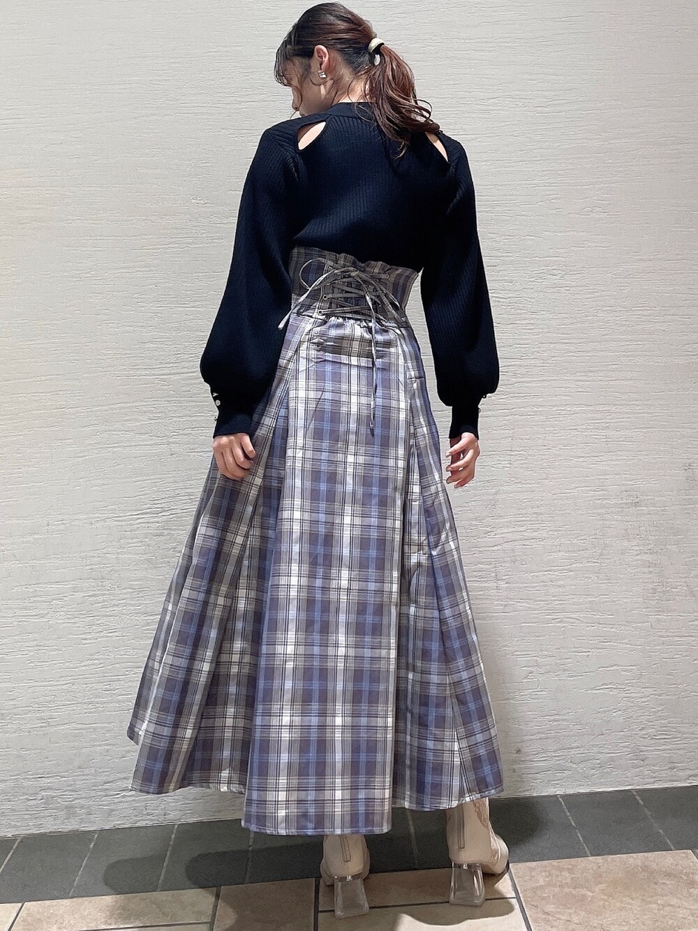 ブラック系のニット/セーター、パープル系のスカート、ベージュ系のブーツを着用したレディースの冬コーディネートの3枚目の写真