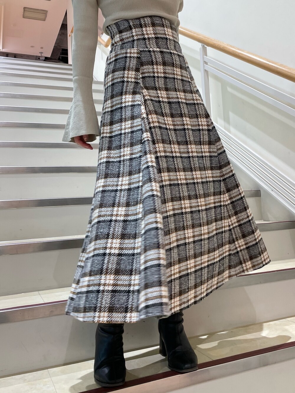 グレー系のニット/セーター、その他のスカート、ブラック系のブーツを着用したレディースの秋コーディネートの10枚目の写真