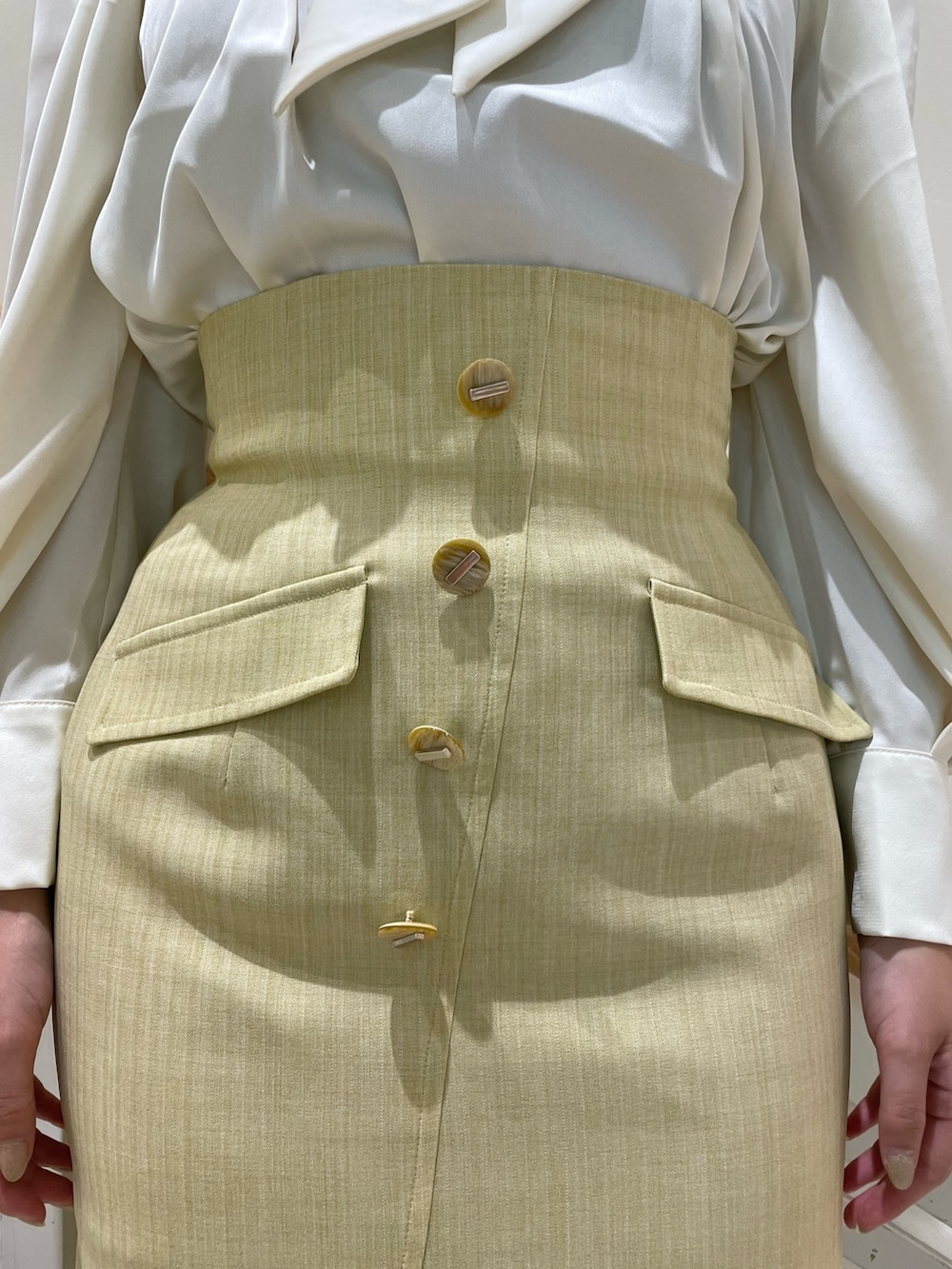 ホワイト系のシャツ/ブラウス、イエロー系のスカート、ベージュ系のブーツを着用したレディースの夏コーディネートの8枚目の写真