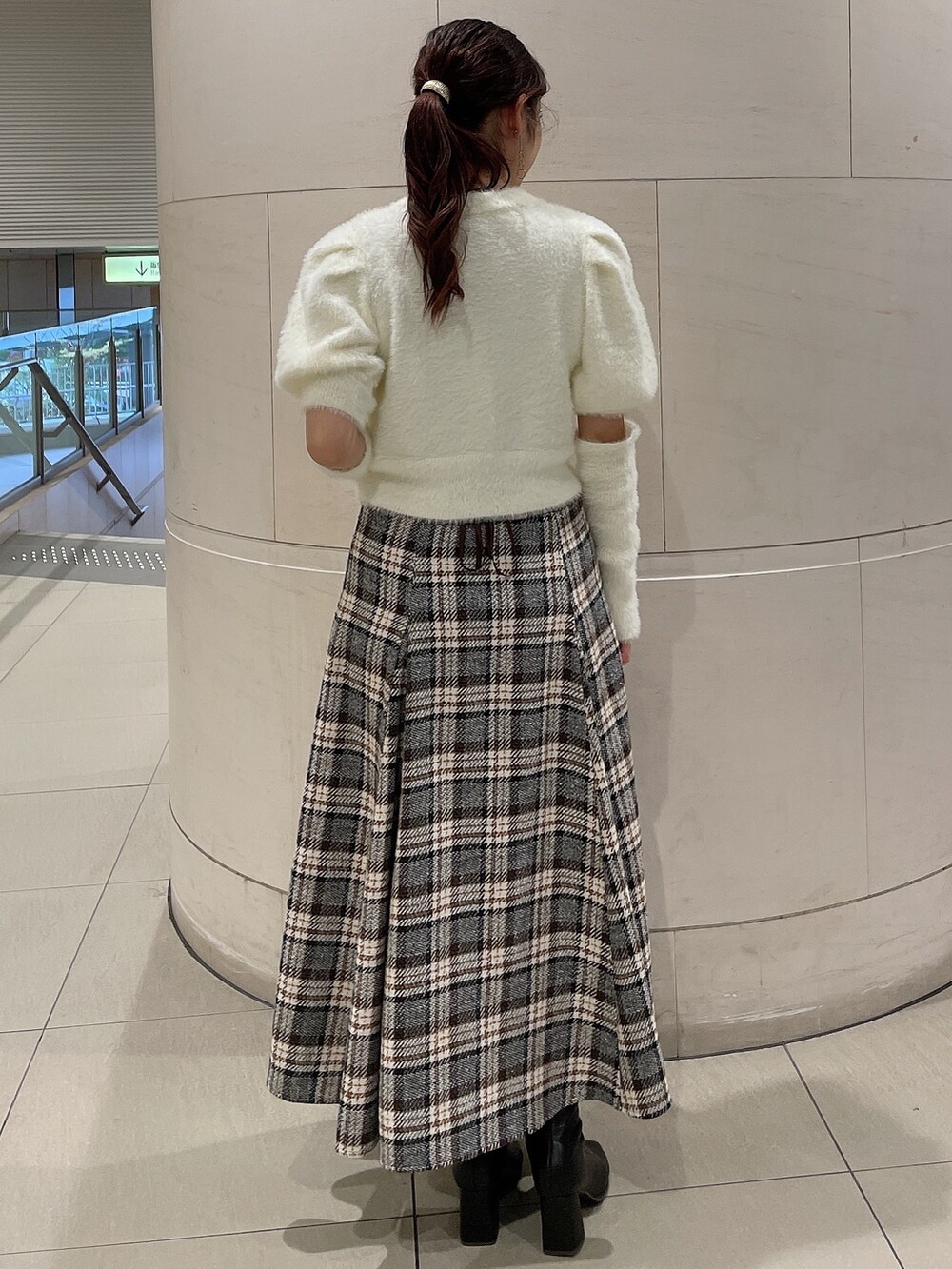 ホワイト系のニット/セーター、その他のスカート、ブラック系のブーツを着用したレディースの秋コーディネートの3枚目の写真