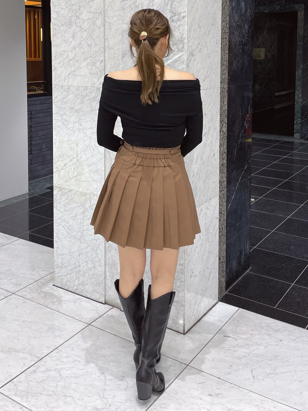 ブラック系のTシャツ/カットソー、ブラウン系のスカート、その他のブーツを着用したレディースの冬コーディネートの5枚目の写真