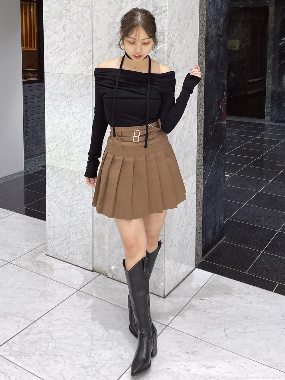 ブラック系のTシャツ/カットソー、ブラウン系のスカート、その他のブーツを着用したレディースの冬コーディネートの3枚目の写真