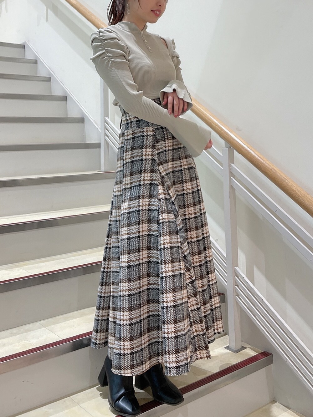 グレー系のニット/セーター、その他のスカート、ブラック系のブーツを着用したレディースの秋コーディネートの2枚目の写真