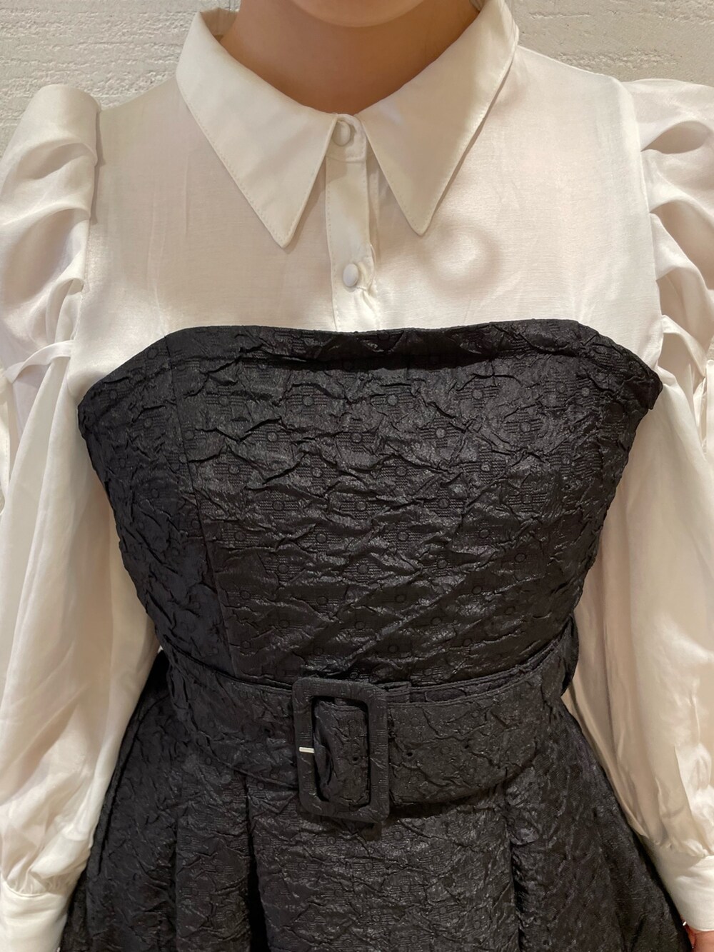 ブラック系のワンピース、ホワイト系のパンプスを着用したレディースの春コーディネートの5枚目の写真