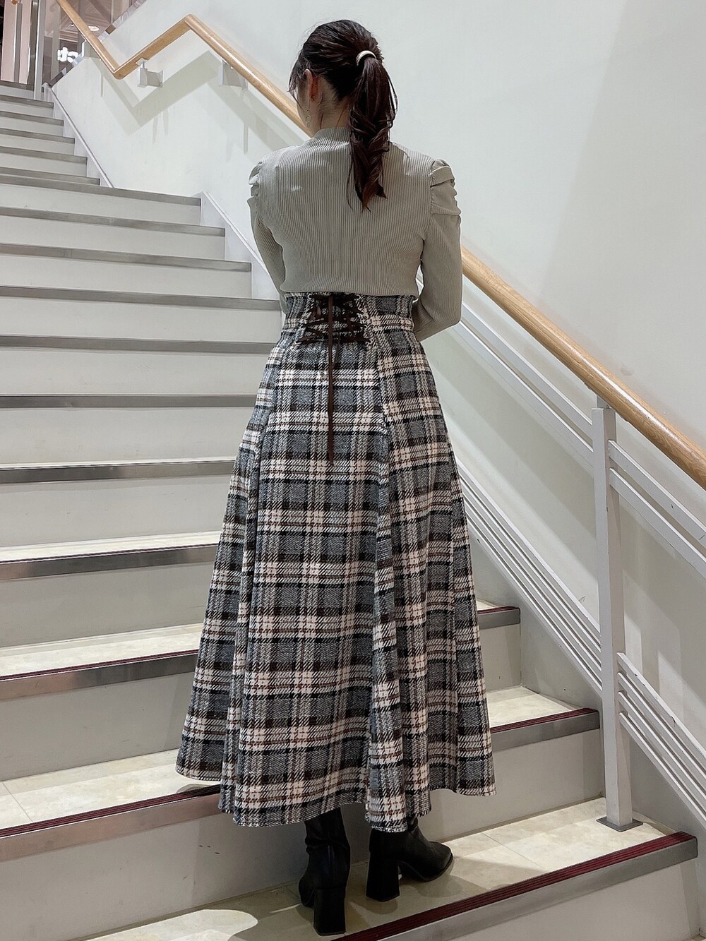 グレー系のニット/セーター、その他のスカート、ブラック系のブーツを着用したレディースの秋コーディネートの3枚目の写真