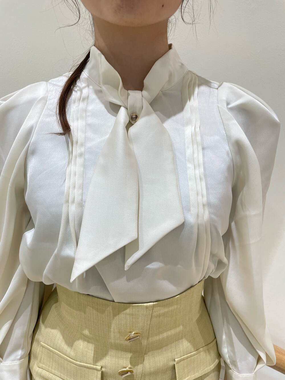 ホワイト系のシャツ/ブラウス、イエロー系のスカート、ベージュ系のブーツを着用したレディースの夏コーディネートの7枚目の写真