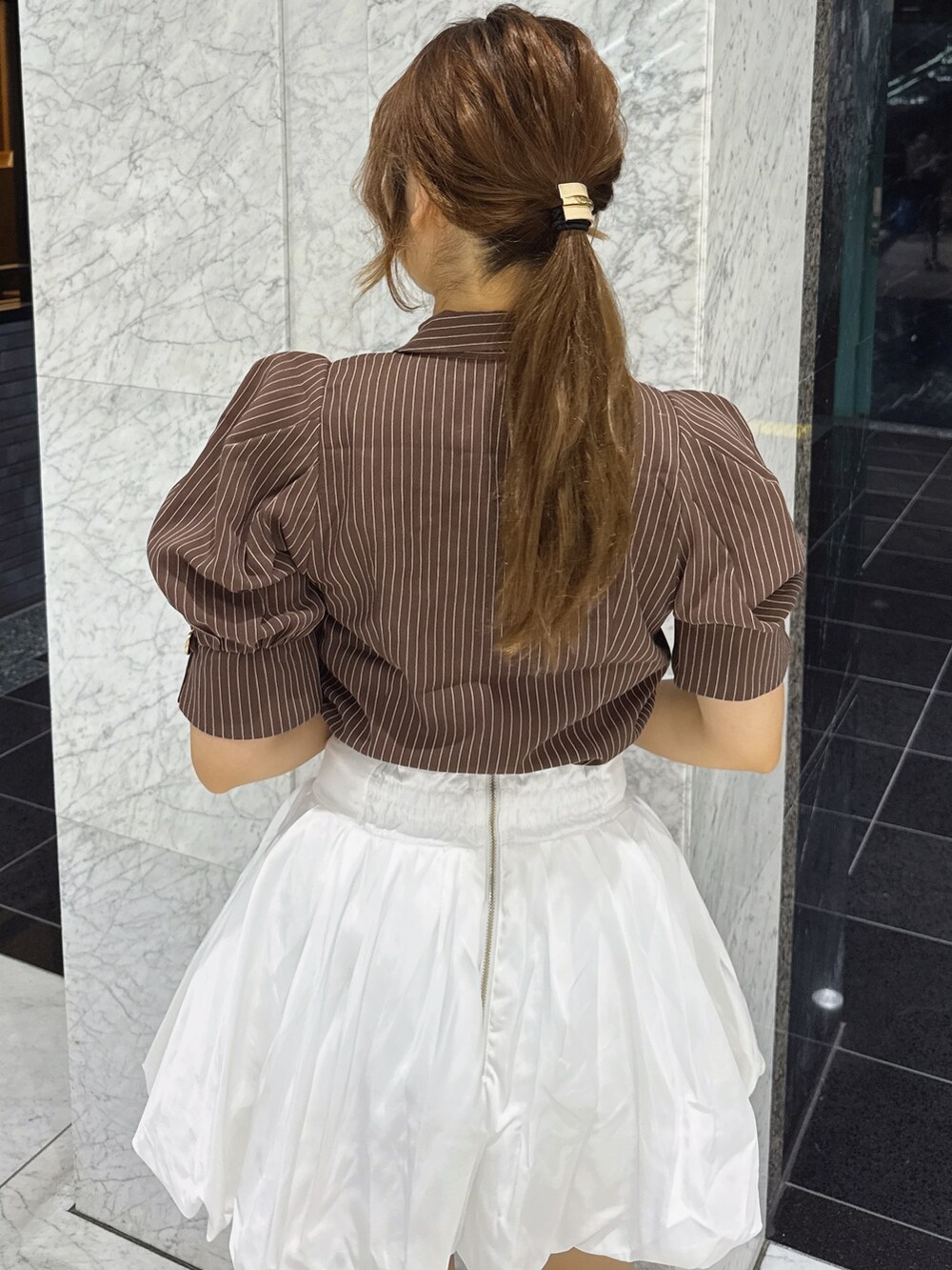 ブラウン系のシャツ/ブラウス、ホワイト系のスカート、ブラウン系のサンダルを着用したレディースの夏コーディネートの7枚目の写真