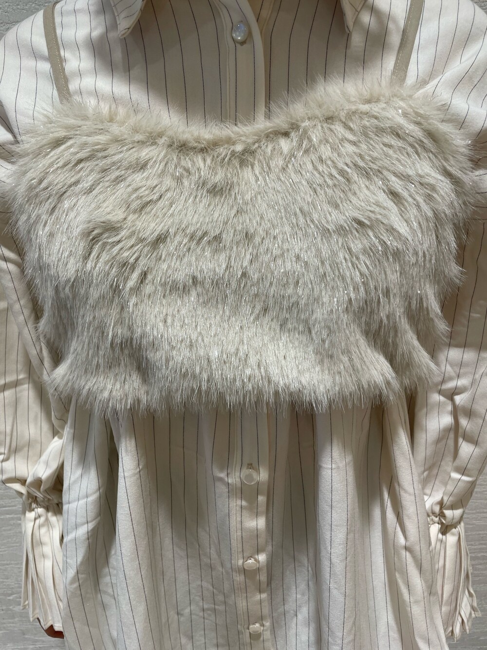 ベージュ系のベスト、ベージュ系のワンピース、ベージュ系のブーツを着用したレディースの夏コーディネートの7枚目の写真