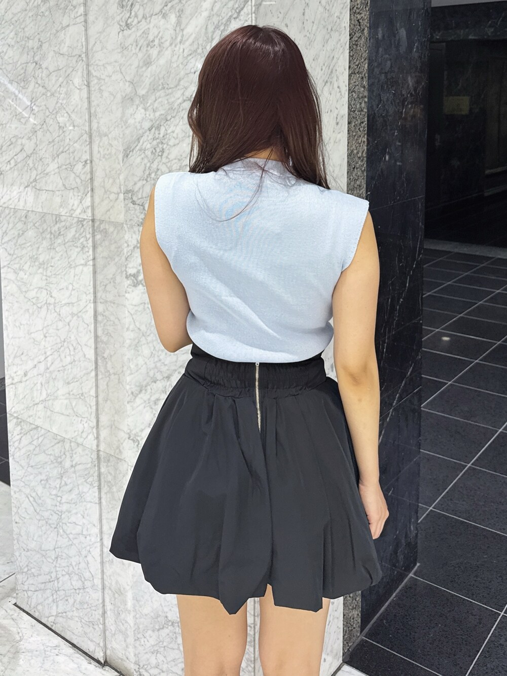 ブルー系のニット/セーター、ブラック系のスカート、ブラック系のサンダルを着用したレディースの夏コーディネートの8枚目の写真