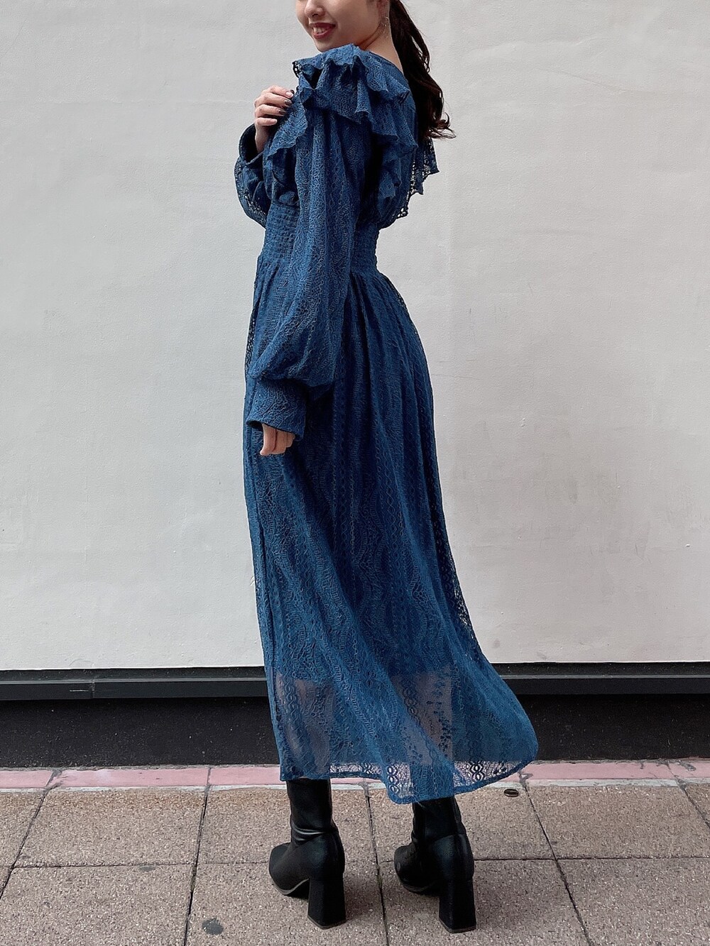 ブルー系のワンピース、ブラック系のブーツを着用したレディースの冬コーディネートの3枚目の写真