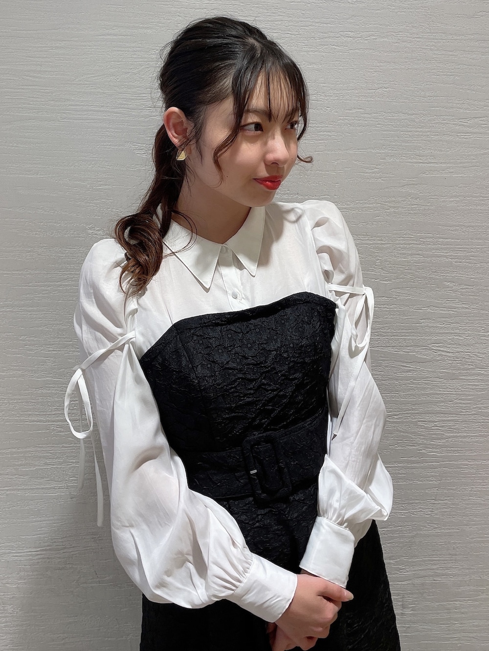 ブラック系のワンピース、ホワイト系のパンプスを着用したレディースの春コーディネートの3枚目の写真