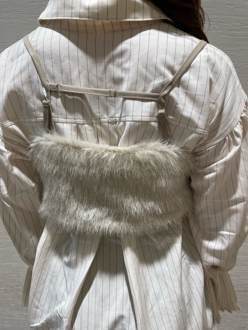 ベージュ系のベスト、ベージュ系のワンピース、ベージュ系のブーツを着用したレディースの夏コーディネートの8枚目の写真