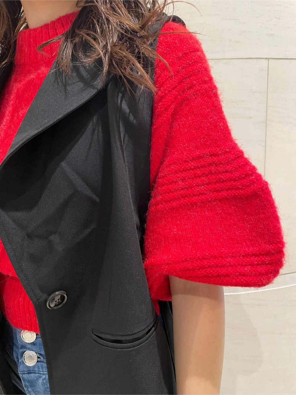 ブラック系のベスト、ブラック系のブーツ、レッド系のニット/セーターを着用したレディースの秋コーディネートの6枚目の写真