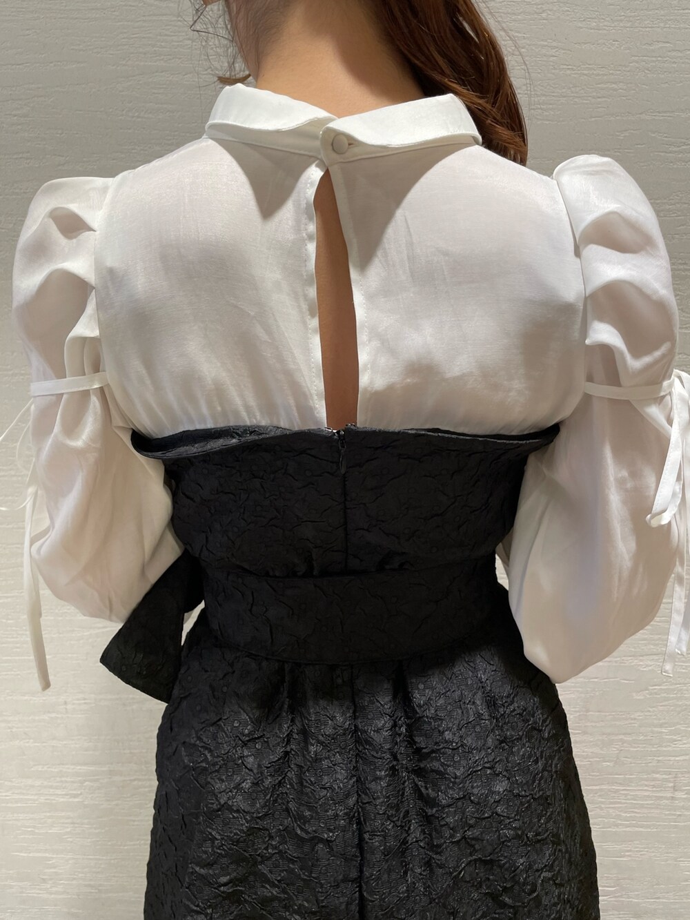 ブラック系のワンピース、ホワイト系のパンプスを着用したレディースの春コーディネートの7枚目の写真