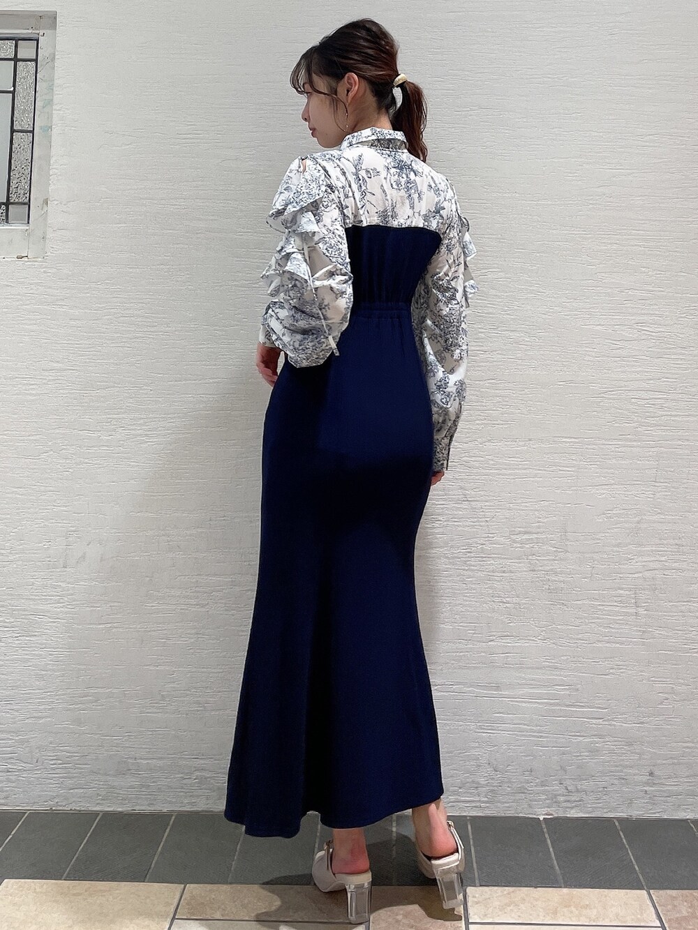 ブルー系のワンピース、ホワイト系のパンプスを着用したレディースの冬コーディネートの4枚目の写真