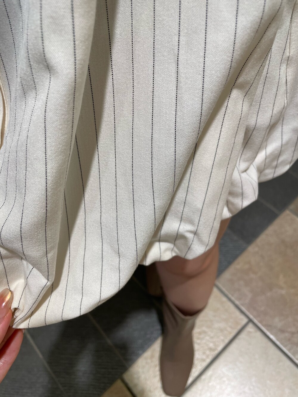 ベージュ系のベスト、ベージュ系のワンピース、ベージュ系のブーツを着用したレディースの夏コーディネートの9枚目の写真