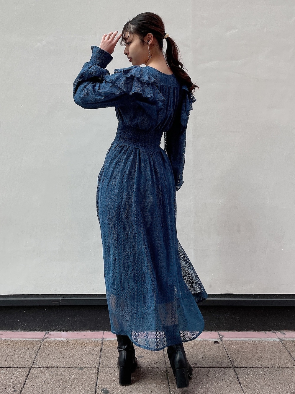 ブルー系のワンピース、ブラック系のブーツを着用したレディースの冬コーディネートの2枚目の写真