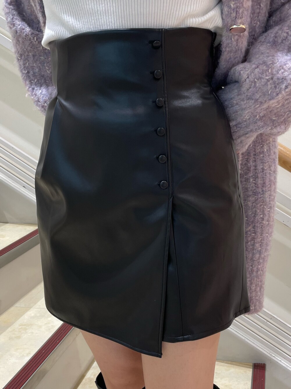 ブラック系のブーツ、ホワイト系のニット/セーター、パープル系のカーディガン/ボレロを着用したレディースの秋コーディネートの10枚目の写真