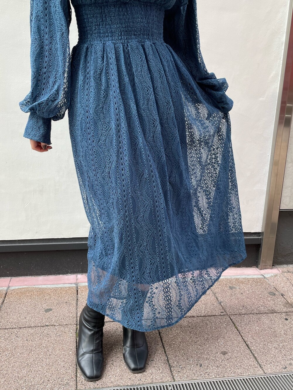 ブルー系のワンピース、ブラック系のブーツを着用したレディースの冬コーディネートの9枚目の写真