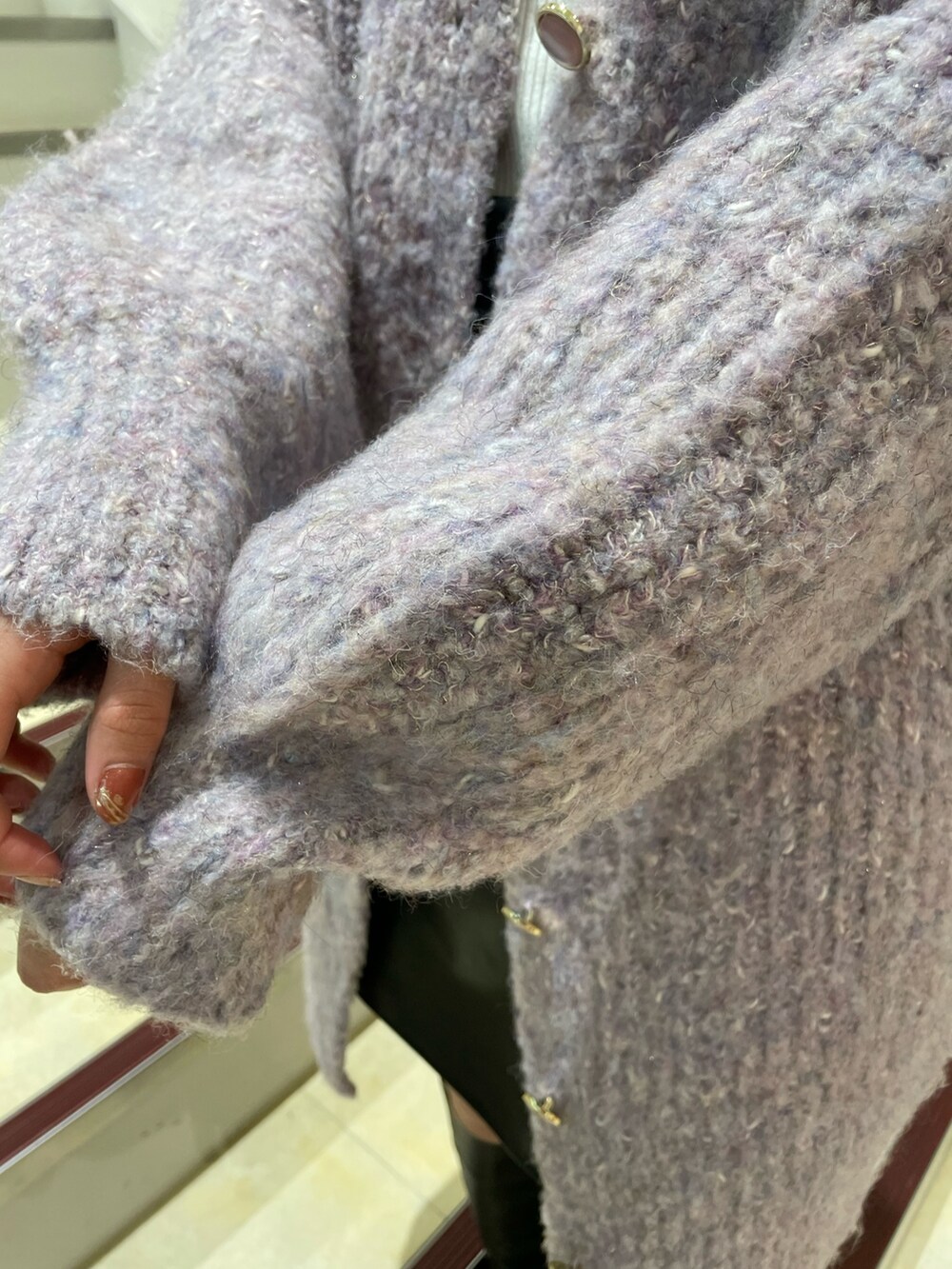 ブラック系のブーツ、ホワイト系のニット/セーター、パープル系のカーディガン/ボレロを着用したレディースの秋コーディネートの8枚目の写真