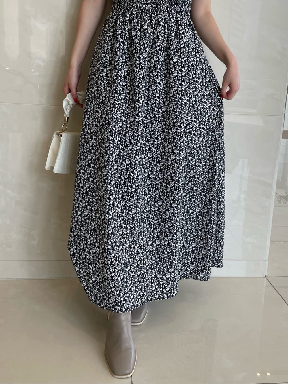 ブラック系のワンピース、ベージュ系のブーツを着用したレディースの夏コーディネートの8枚目の写真