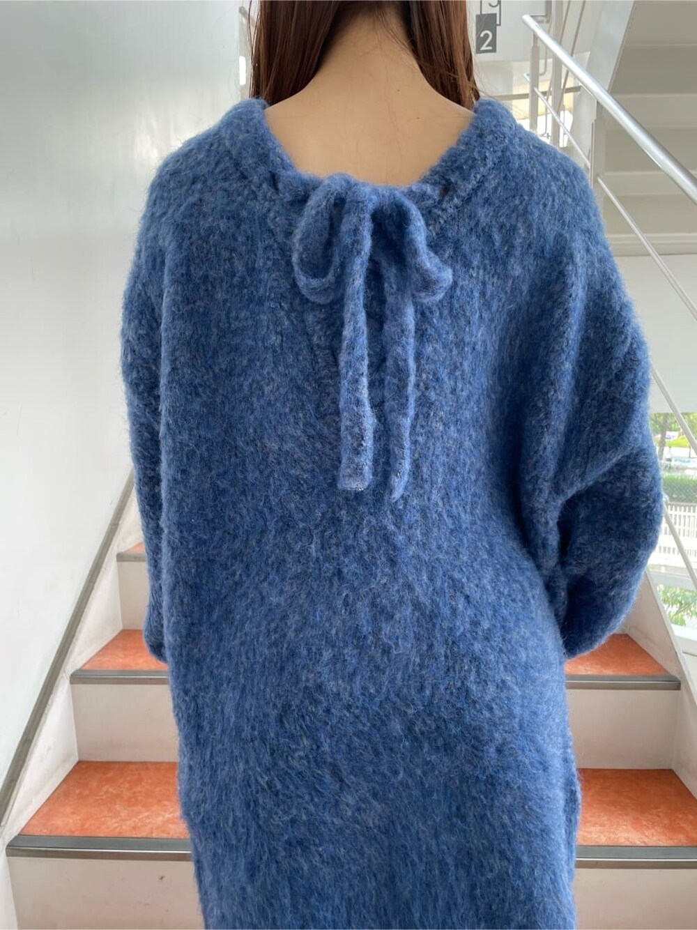 ブラック系のブーツ、ブルー系のニット/セーターを着用したレディースの秋コーディネートの7枚目の写真