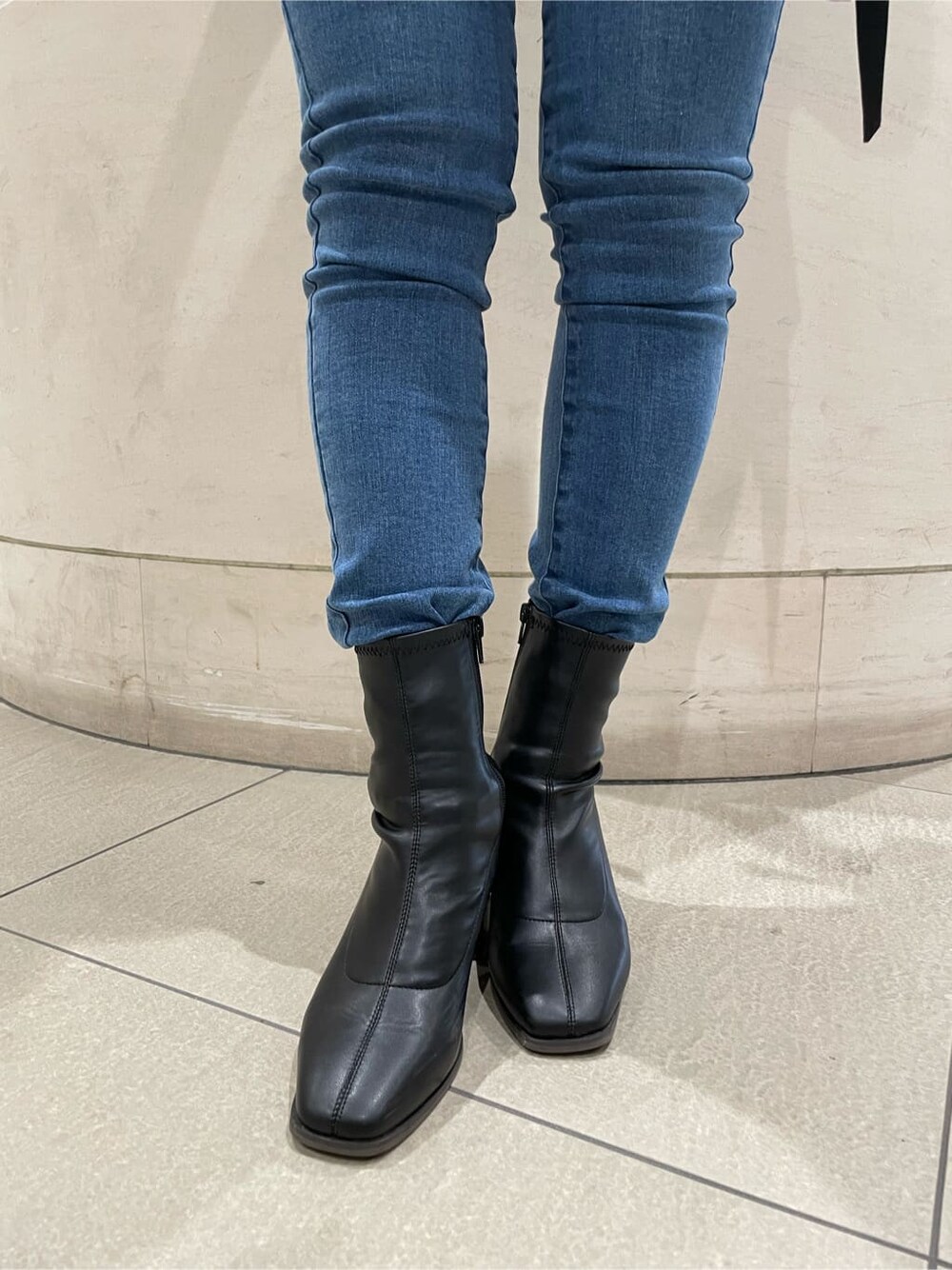 ブラック系のベスト、ブラック系のブーツ、レッド系のニット/セーターを着用したレディースの秋コーディネートの8枚目の写真