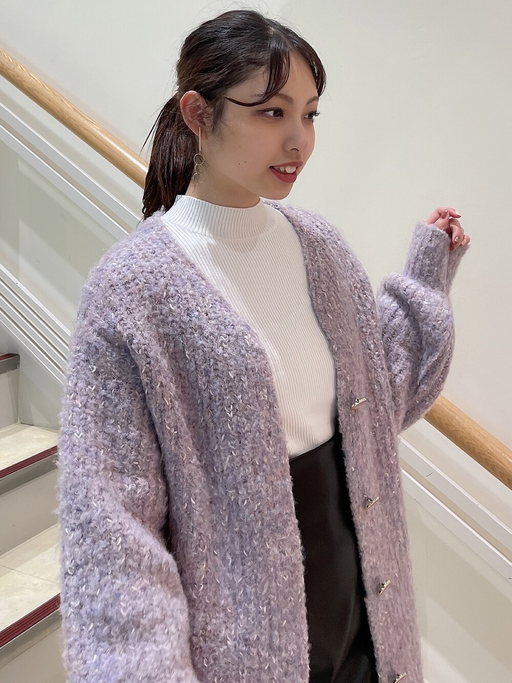 ブラック系のブーツ、ホワイト系のニット/セーター、パープル系のカーディガン/ボレロを着用したレディースの秋コーディネートの3枚目の写真