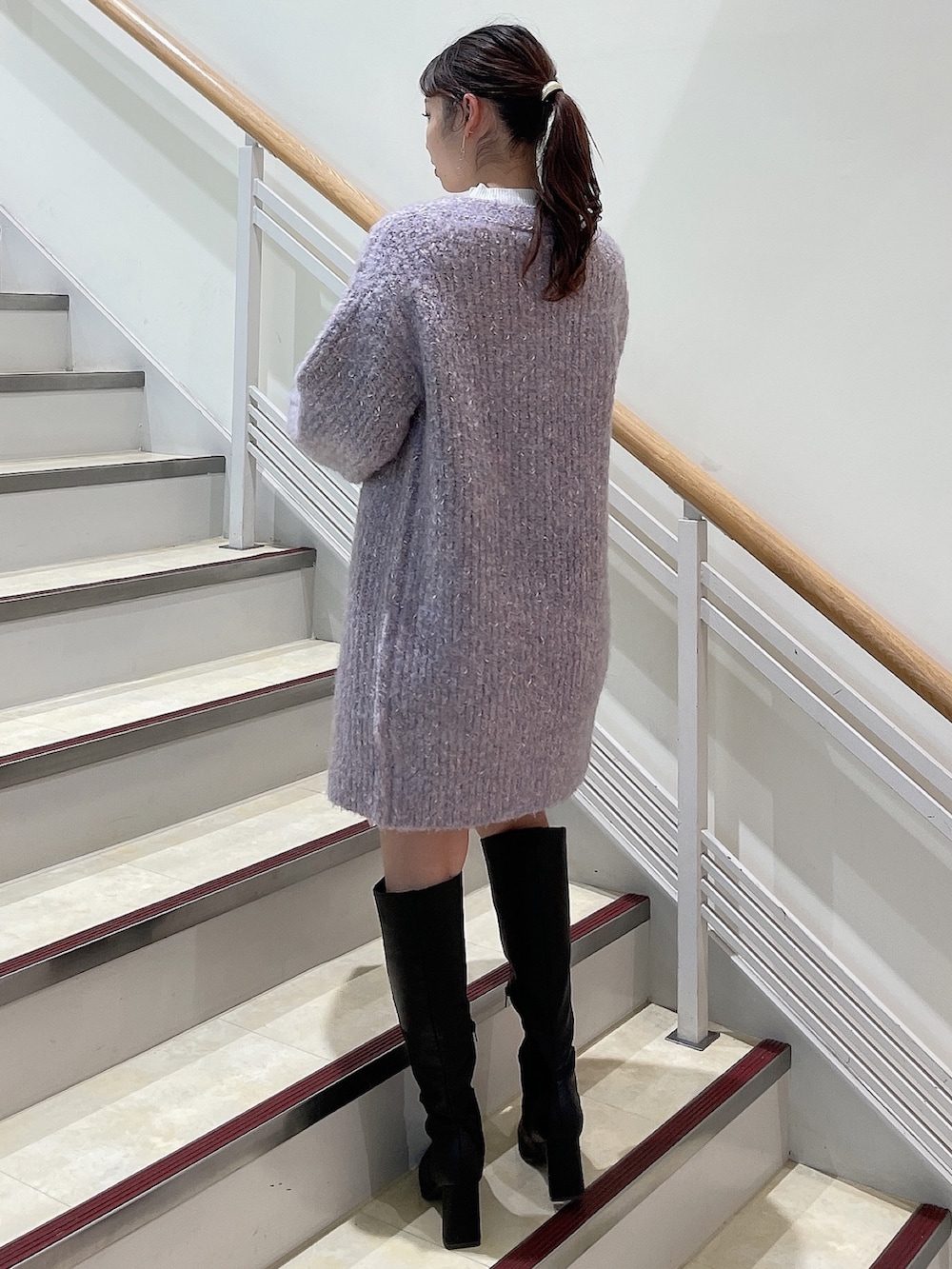 ブラック系のブーツ、ホワイト系のニット/セーター、パープル系のカーディガン/ボレロを着用したレディースの秋コーディネートの2枚目の写真