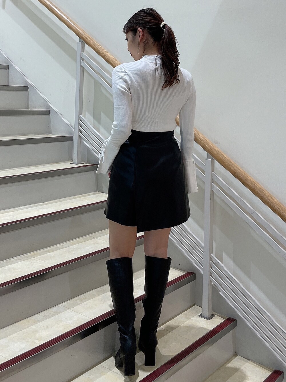 ブラック系のブーツ、ホワイト系のニット/セーター、パープル系のカーディガン/ボレロを着用したレディースの秋コーディネートの6枚目の写真