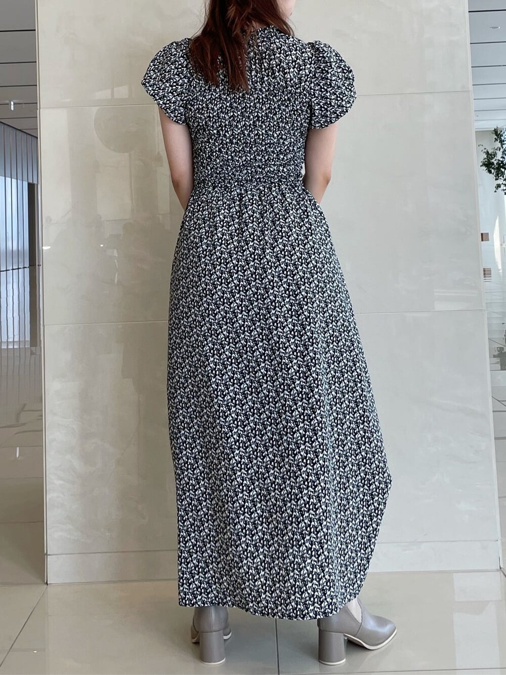 ブラック系のワンピース、ベージュ系のブーツを着用したレディースの夏コーディネートの4枚目の写真