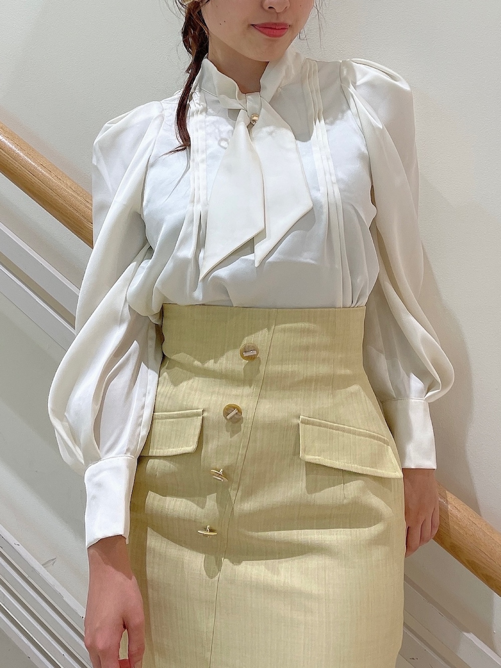 ホワイト系のシャツ/ブラウス、イエロー系のスカート、ベージュ系のブーツを着用したレディースの夏コーディネートの5枚目の写真