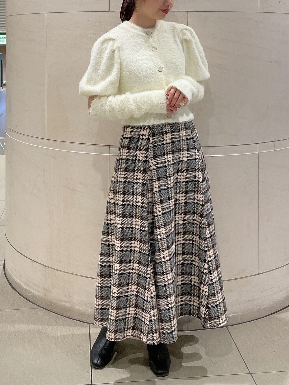 ホワイト系のニット/セーター、その他のスカート、ブラック系のブーツを着用したレディースの秋コーディネートの2枚目の写真