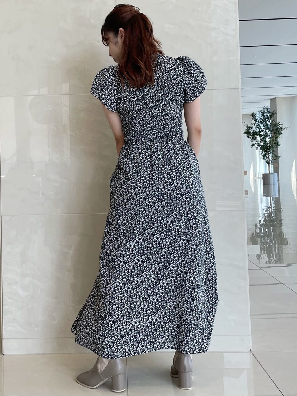 ブラック系のワンピース、ベージュ系のブーツを着用したレディースの夏コーディネートの5枚目の写真