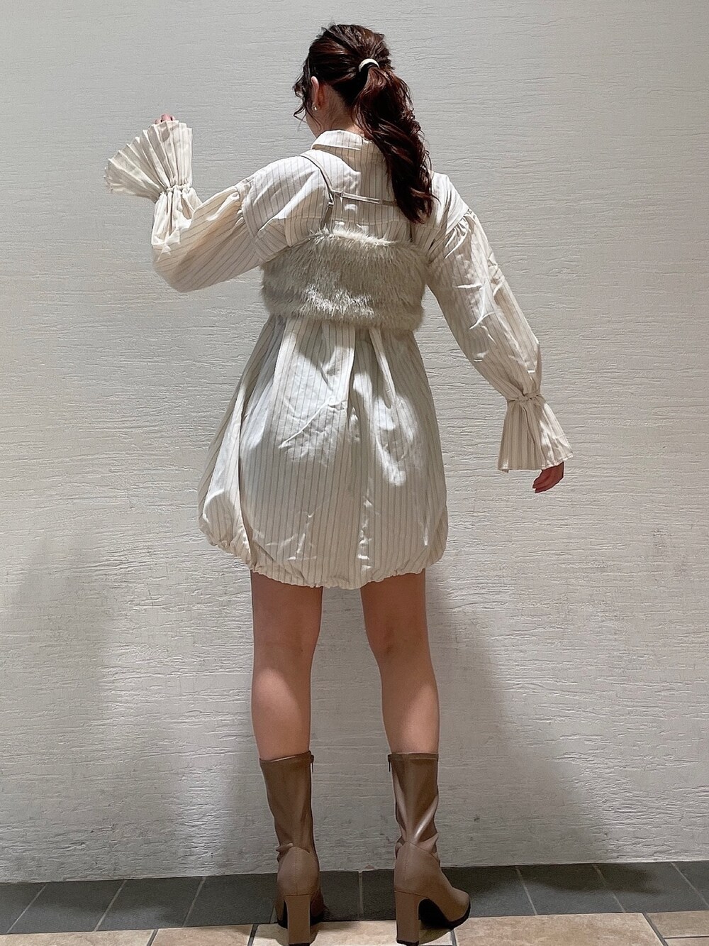 ベージュ系のベスト、ベージュ系のワンピース、ベージュ系のブーツを着用したレディースの夏コーディネートの3枚目の写真