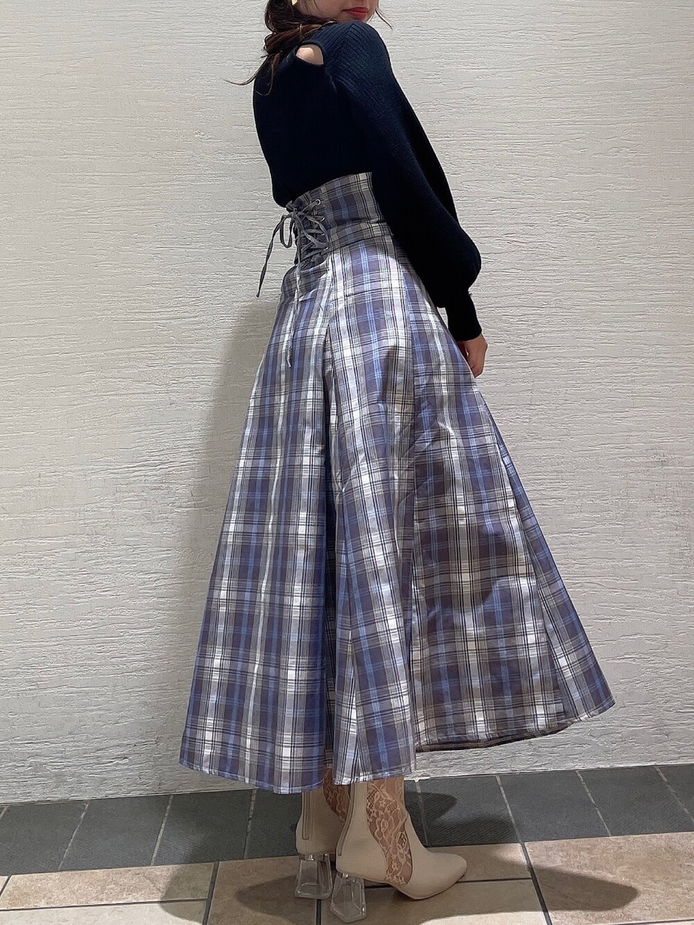 ブラック系のニット/セーター、パープル系のスカート、ベージュ系のブーツを着用したレディースの冬コーディネートの2枚目の写真