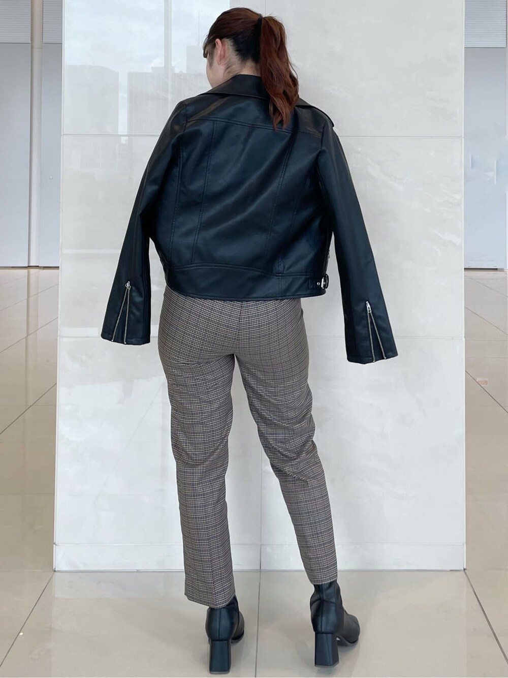 ブラック系のライダースジャケット、ブルー系のその他パンツ、ブラック系のTシャツ/カットソーを着用したレディースの秋コーディネートの2枚目の写真