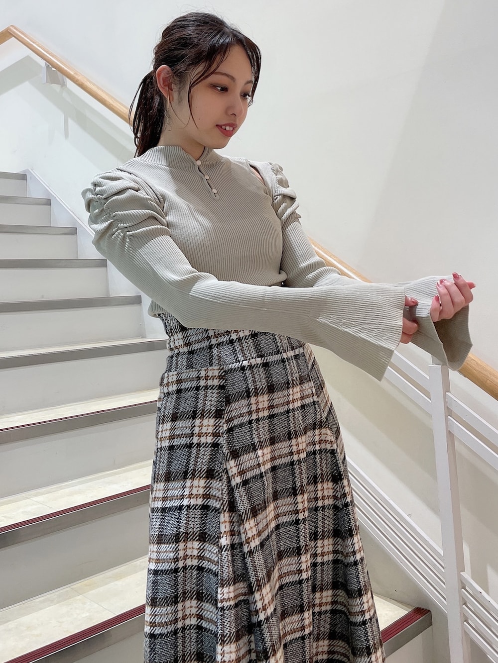 グレー系のニット/セーター、その他のスカート、ブラック系のブーツを着用したレディースの秋コーディネートの4枚目の写真