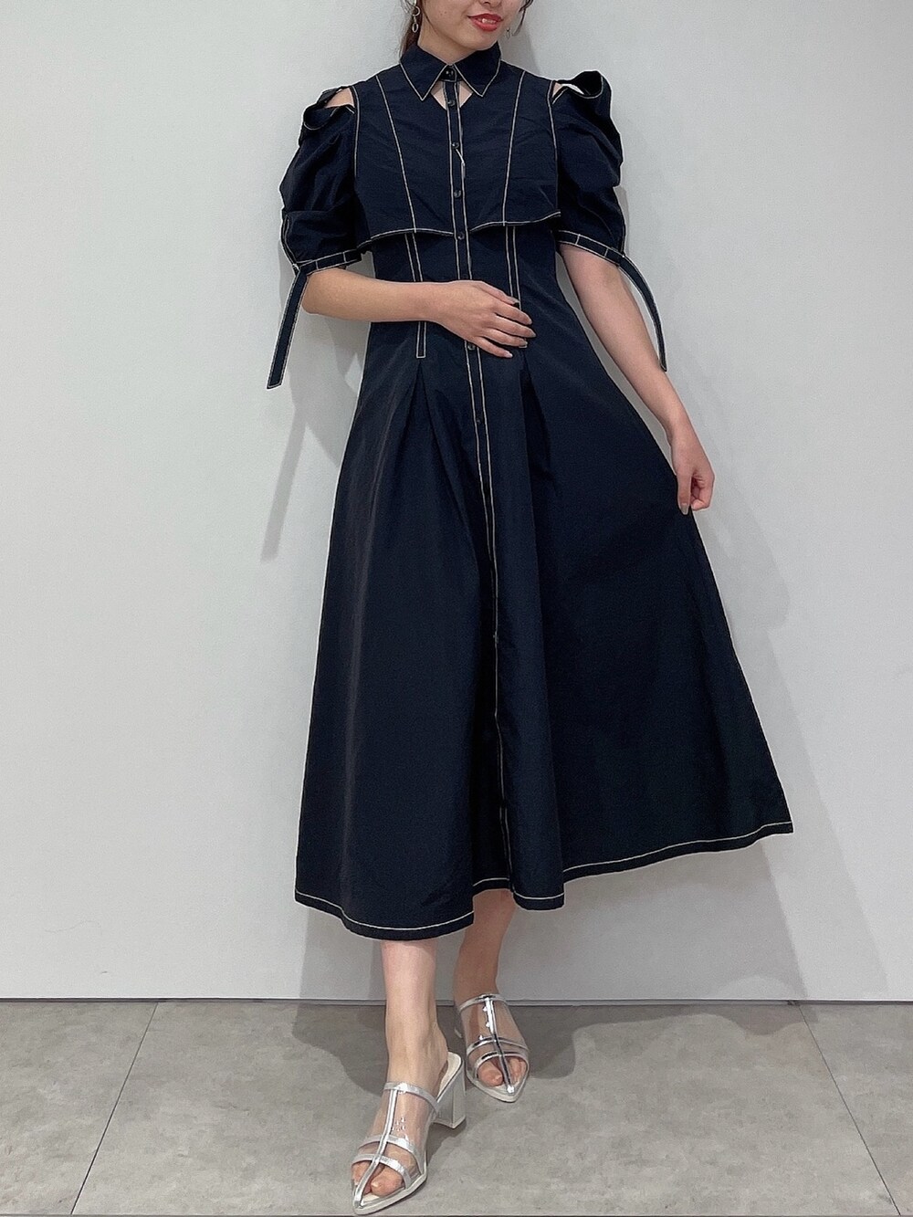 ブラック系のシャツワンピース、シルバー系のパンプスを着用したレディースの春コーディネートの2枚目の写真