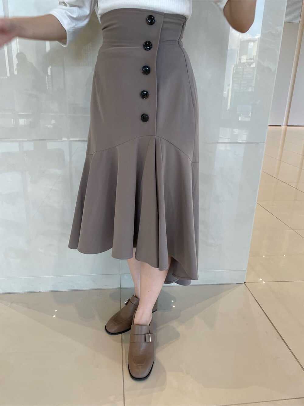 ベージュ系のスカート、ベージュ系のローファー、ホワイト系のTシャツ/カットソーを着用したレディースの夏コーディネートの8枚目の写真