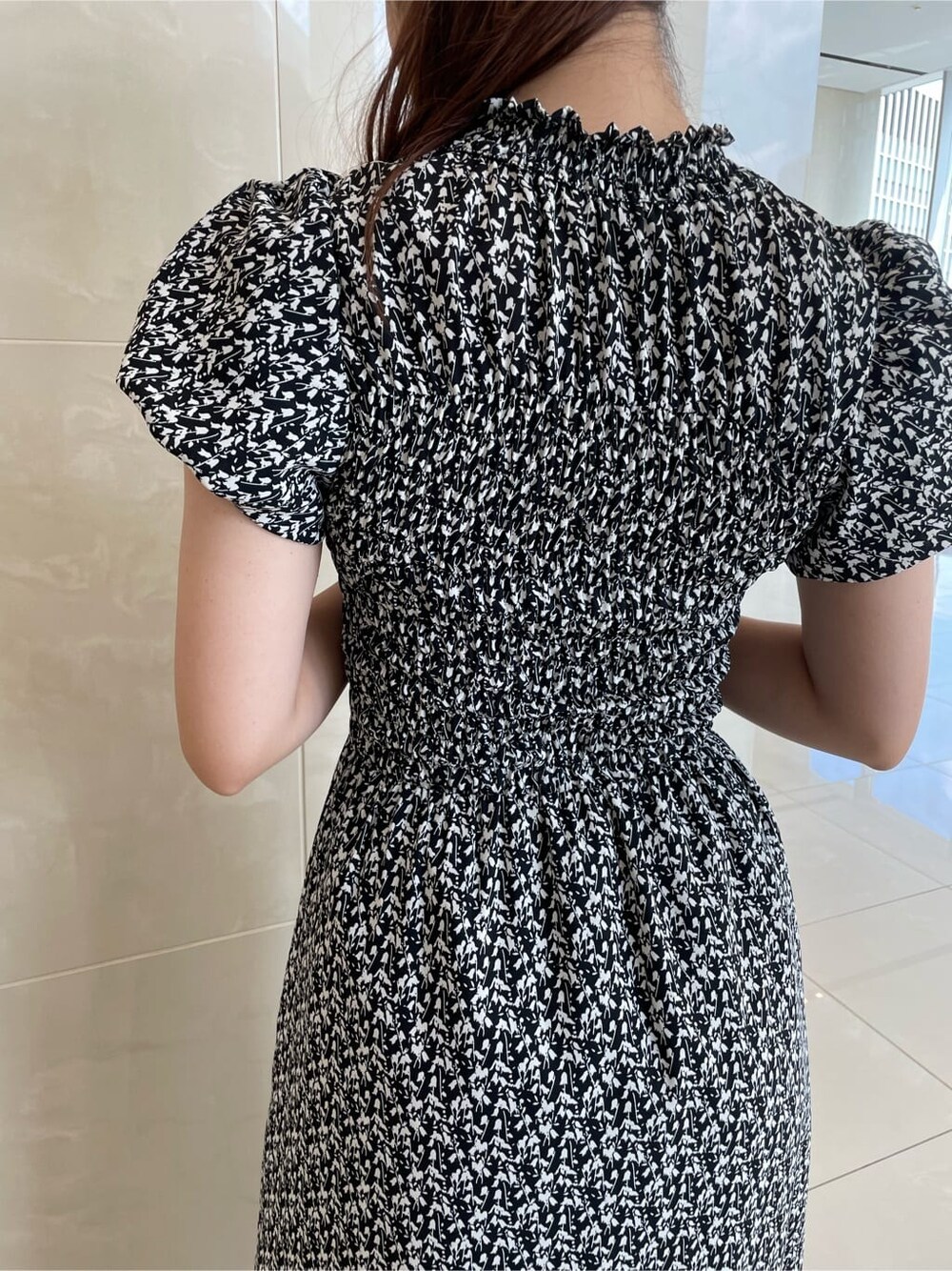 ブラック系のワンピース、ベージュ系のブーツを着用したレディースの夏コーディネートの7枚目の写真