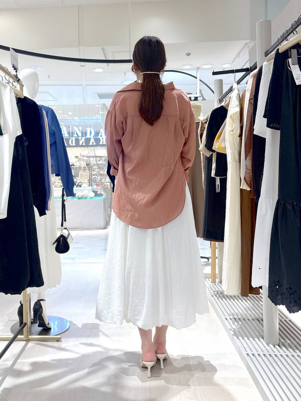 ベージュ系のかごバッグ、ホワイト系のサンダル、ホワイト系のTシャツ/カットソーを着用したレディースの夏コーディネートの5枚目の写真