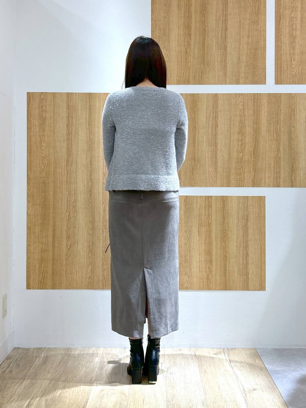 ブラック系のブーツ、ブラック系のショルダーバッグ、グレー系のスカートを着用したレディースの秋コーディネートの4枚目の写真