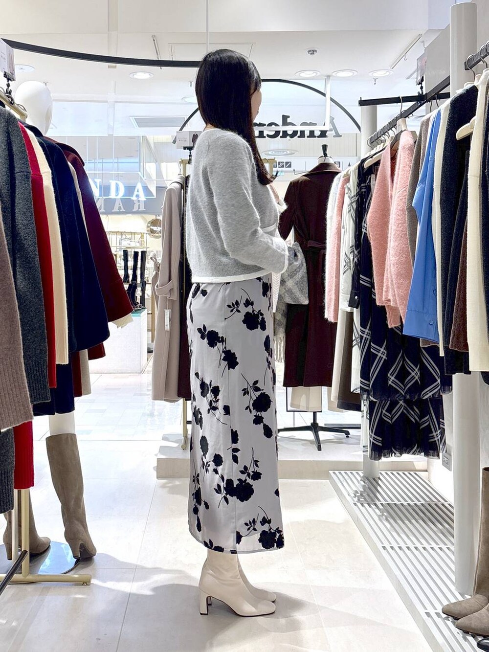 グレー系のカーディガン/ボレロ、ホワイト系のブーツ、ホワイト系のショルダーバッグを着用したレディースの秋コーディネートの3枚目の写真