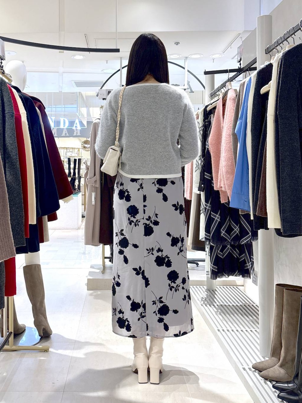 グレー系のカーディガン/ボレロ、ホワイト系のブーツ、ホワイト系のショルダーバッグを着用したレディースの秋コーディネートの4枚目の写真