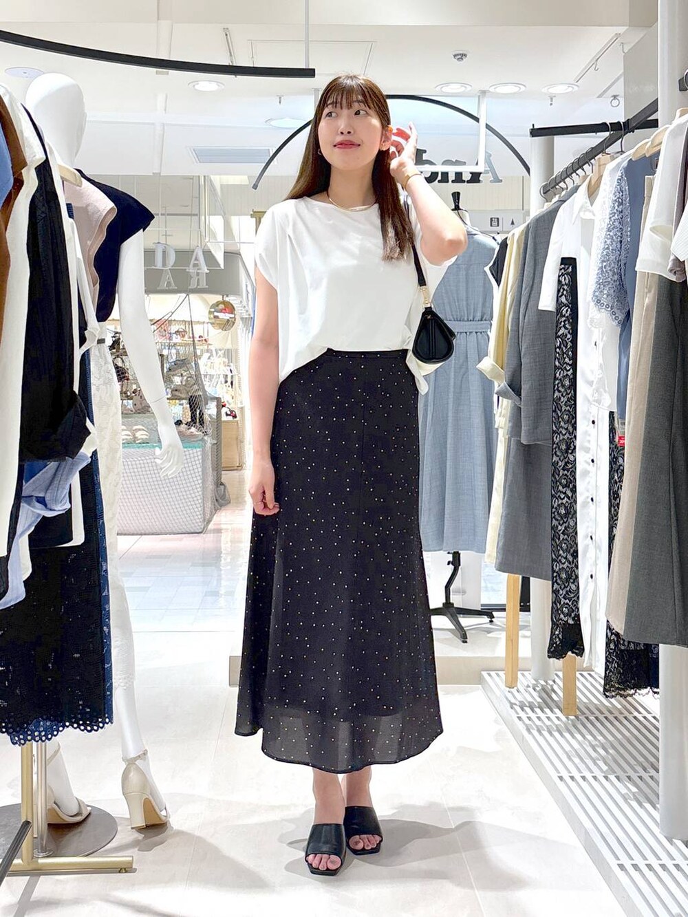 ブラック系のサンダル、ベージュ系のショルダーバッグ、ブラック系のスカートを着用したレディースの夏コーディネートの3枚目の写真