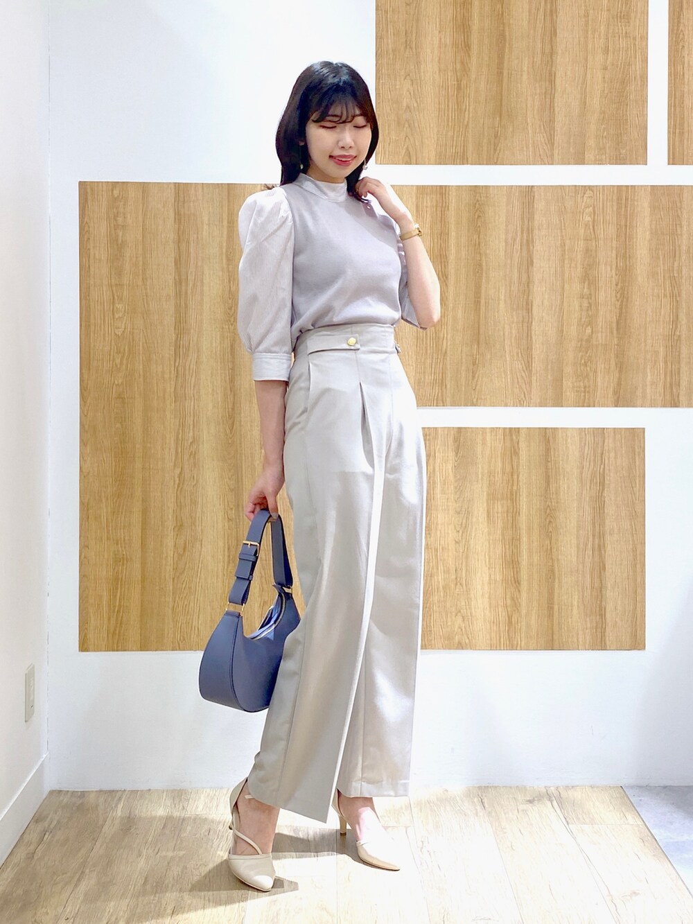 グレー系のニット/セーター、グレー系のその他パンツ、ブルー系のショルダーバッグを着用したレディースの春コーディネートの2枚目の写真